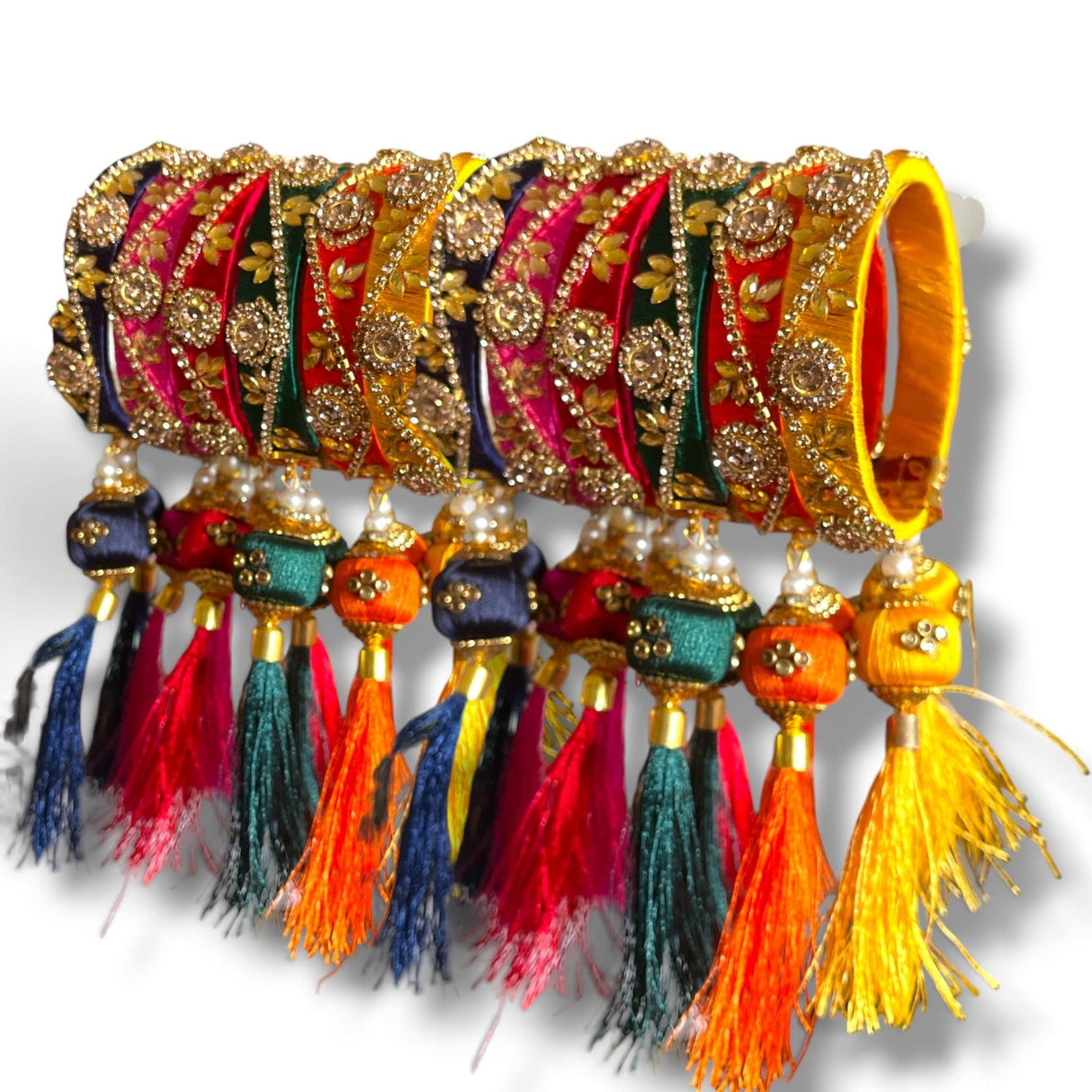 A vibrant set of silk thread bangles for women in red yellow and green with kundan-style work and colorful latkan tassels
