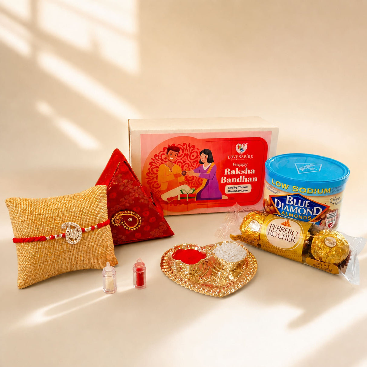 Gold-colored heart-shaped haldi kumkum holder with red and white powders in pure silver ganesha rakhi gift hamper