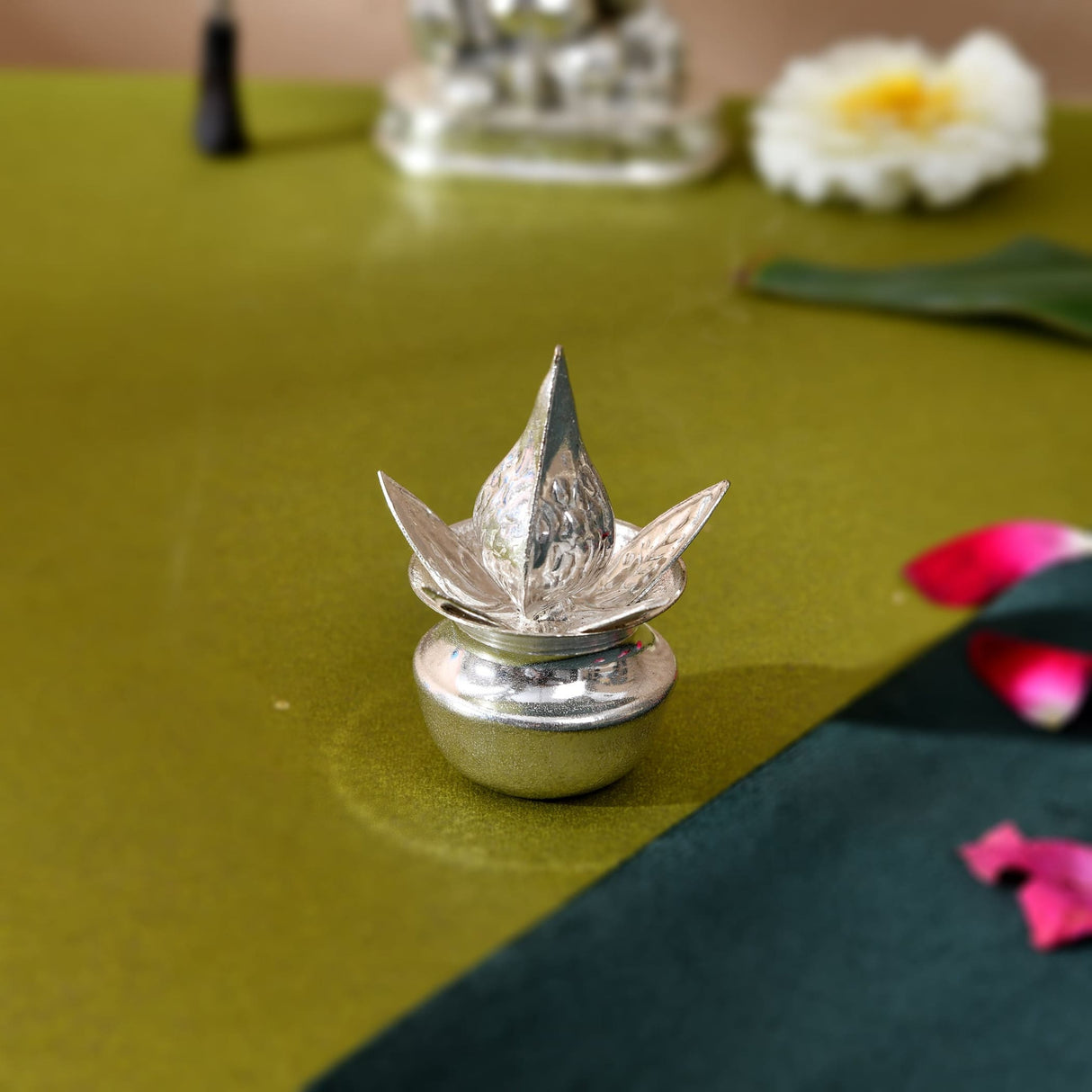 Silver plated mini mangal kalash with intricate lotus shaped petals and rounded base for pooja and home decor