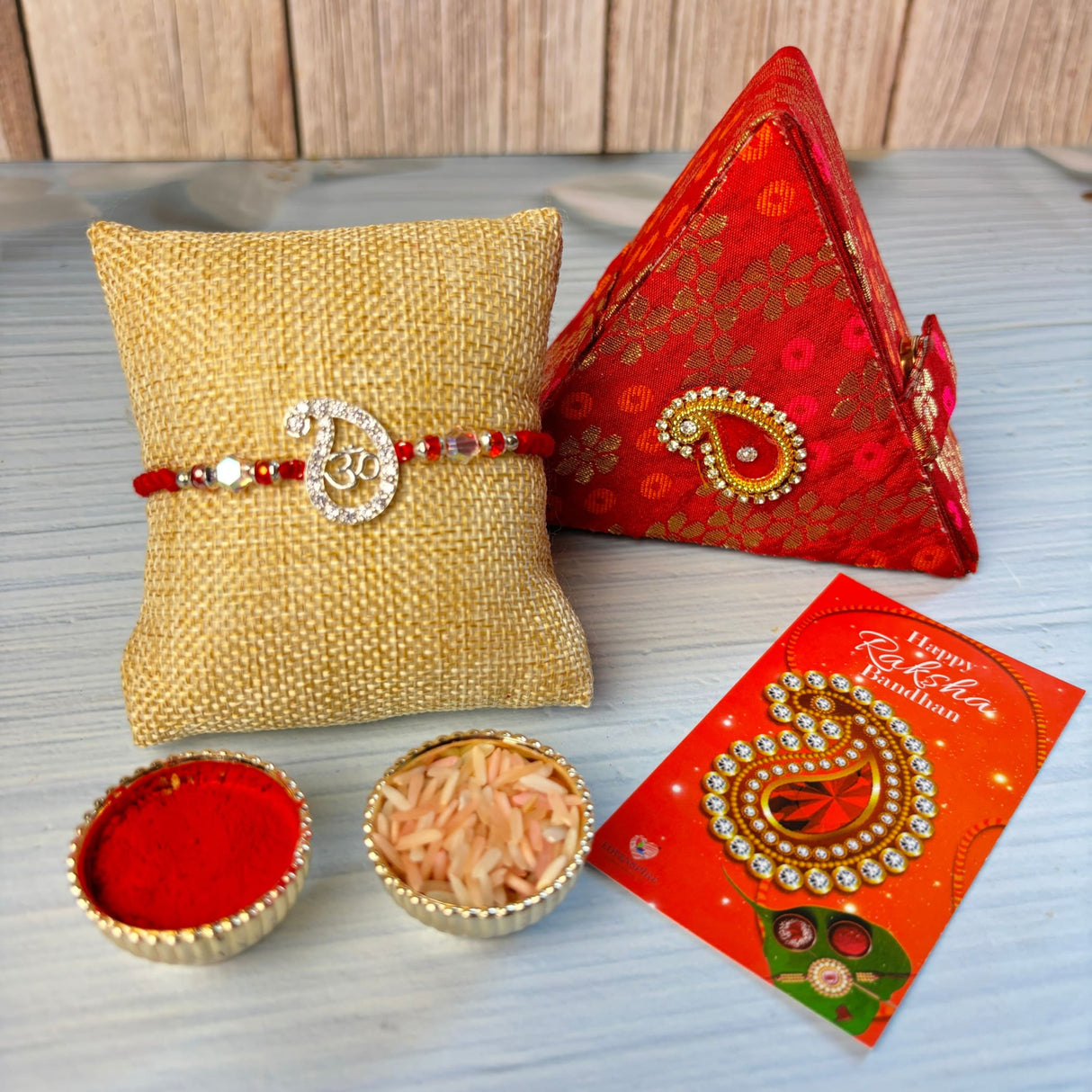 Designer pure silver om rakhi with red and gold beads for Raksha Bandhan comes with brocade box and roli chawal