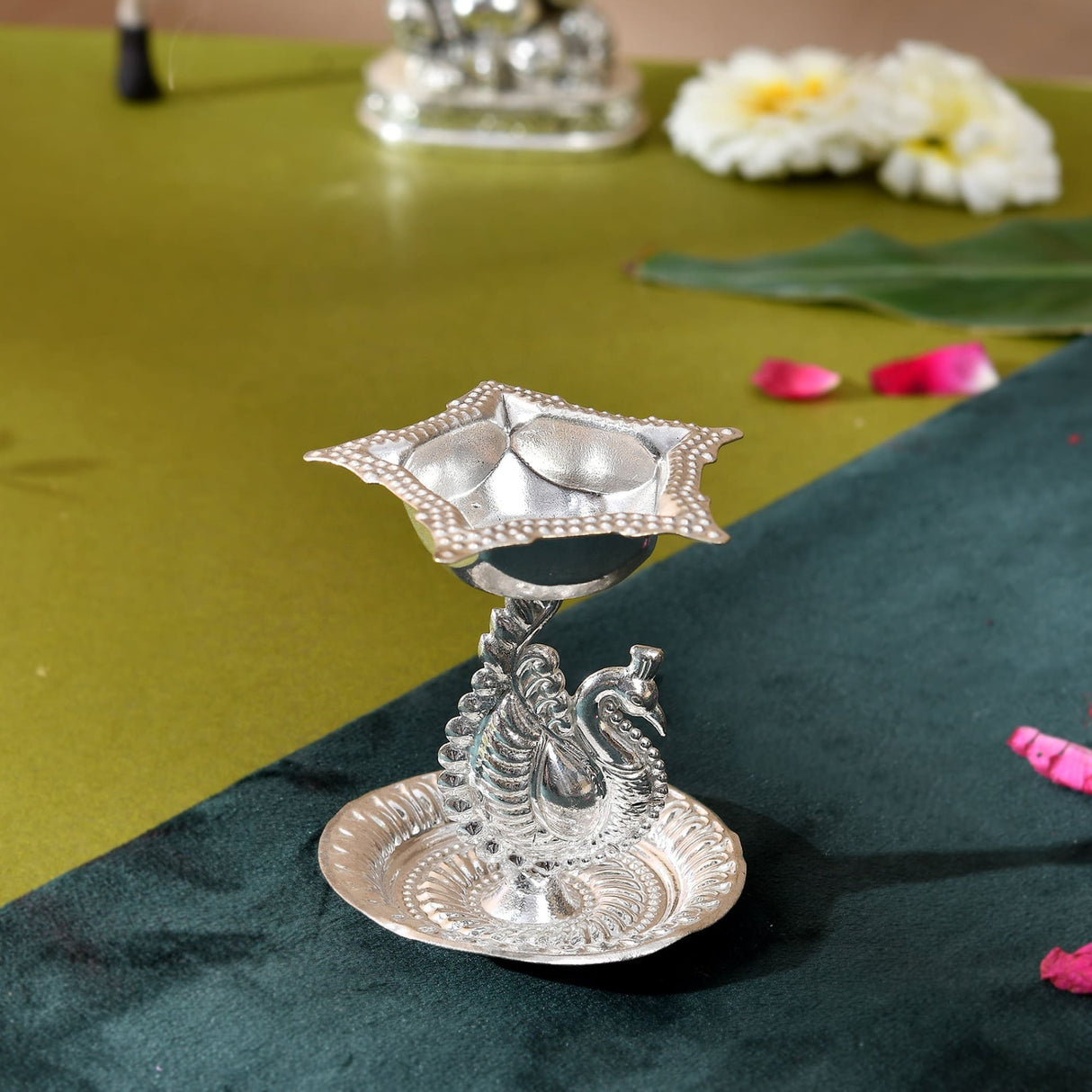 Silver plated peacock diya oil lamp with star-shaped top and ornate base for home pooja mandir and Diwali decor