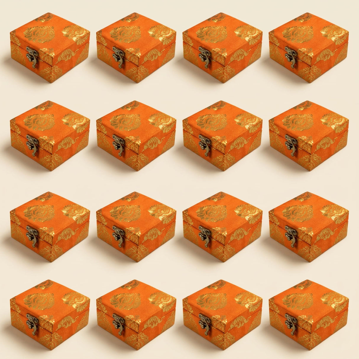 Small handmade orange brocade jewelry boxes with gold floral patterns and metallic clasps for Indian and Pakistani wedding favors