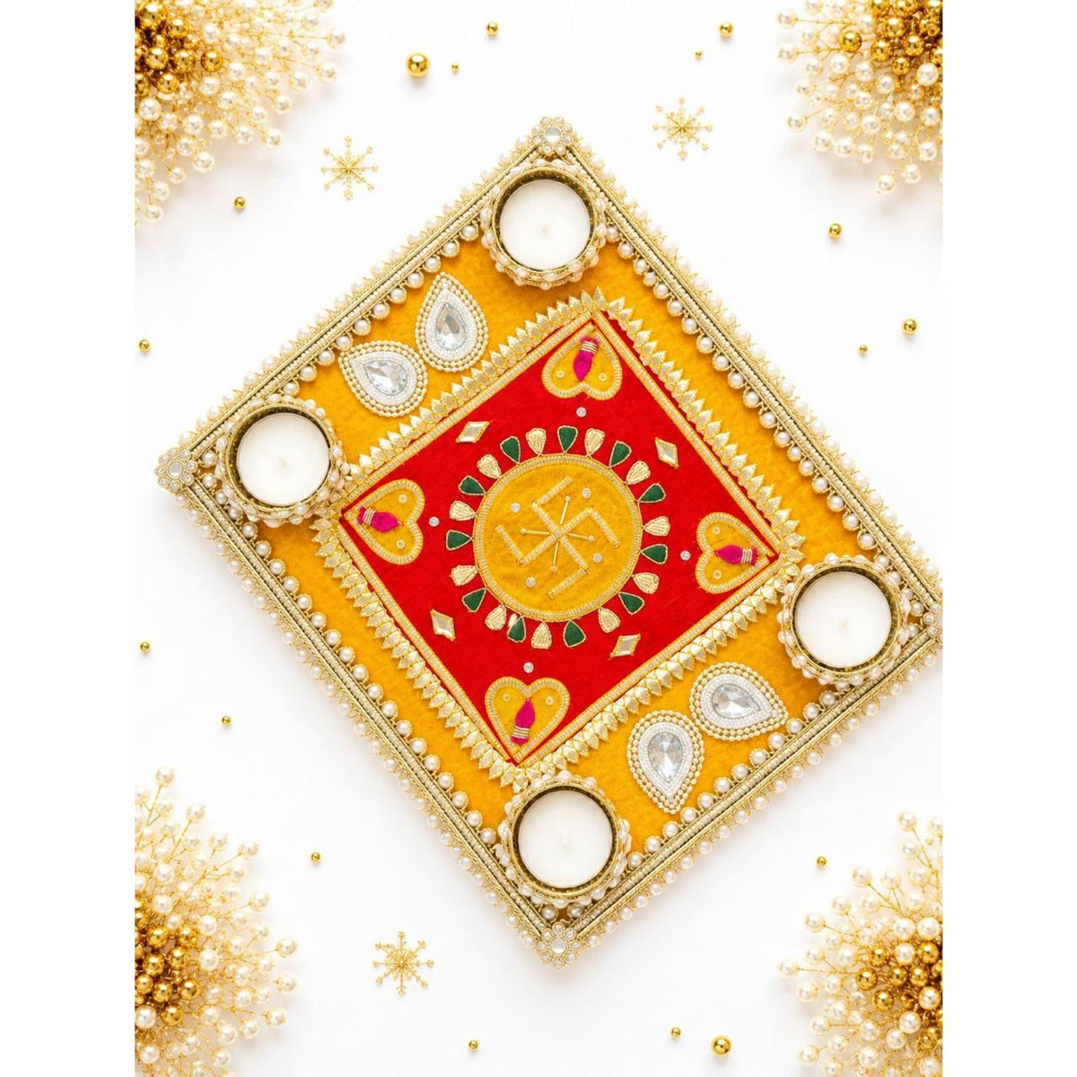 Decorative swastik rangoli mat with a golden and red embroidered diya tray featuring four pearl and gemstone adorned tealight holders