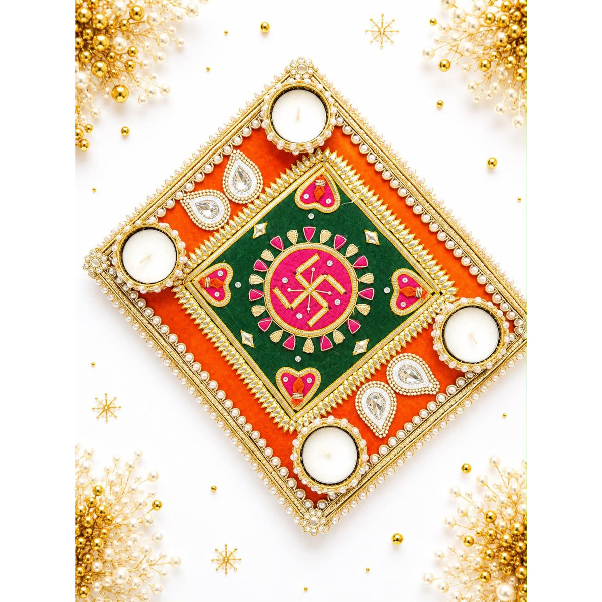 Decorative swastik rangoli mat with ornate square diya holder featuring vibrant orange green fabric gold trim pearls and rhinestones