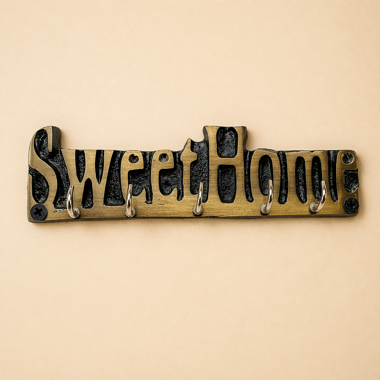 Brass-colored handmade wooden sweet home wall-mounted key holder with black cast metal lettering and five silver hooks