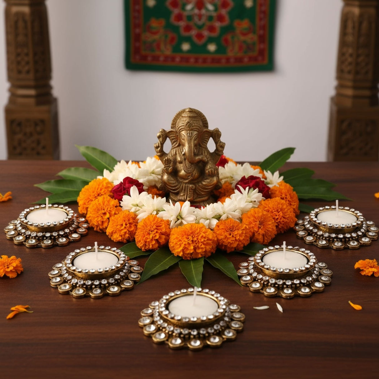 Bronze Ganesh idol with flower garland and tea light candle holders for festival decor