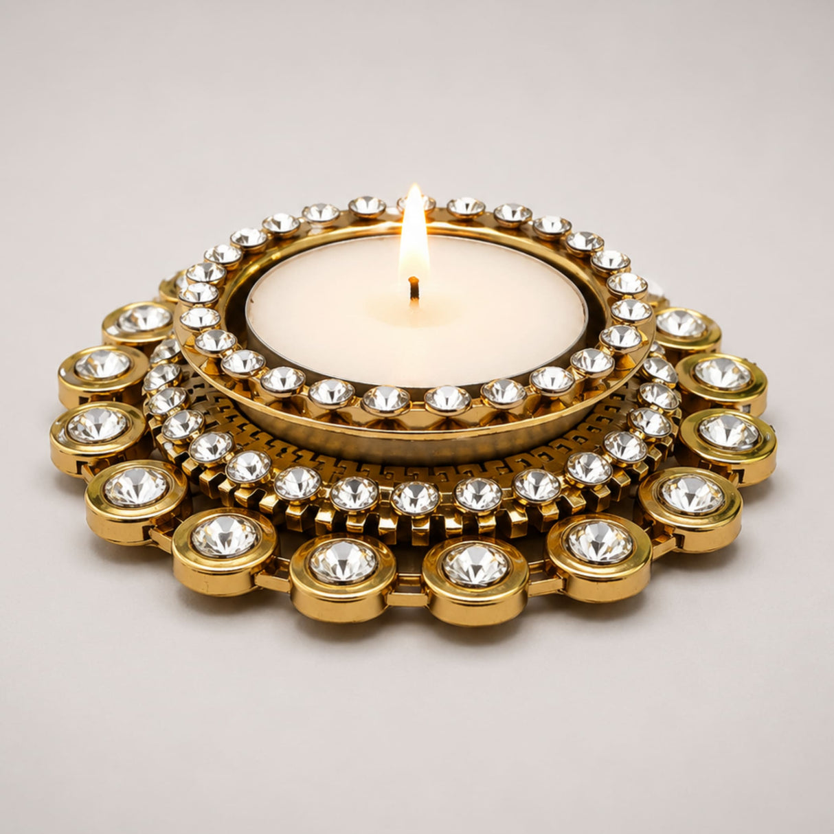Gold-toned tea light candle holder adorned with clear sparkling crystals in concentric circles for festive home decor