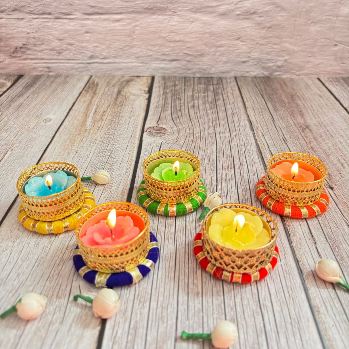 Decorative tealight candles in ornate golden holders with colorful bases for festive home decor
