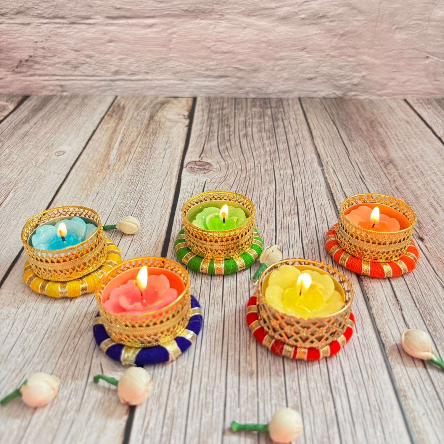Decorative tealight candles in ornate golden holders with colorful bases for festive home decor
