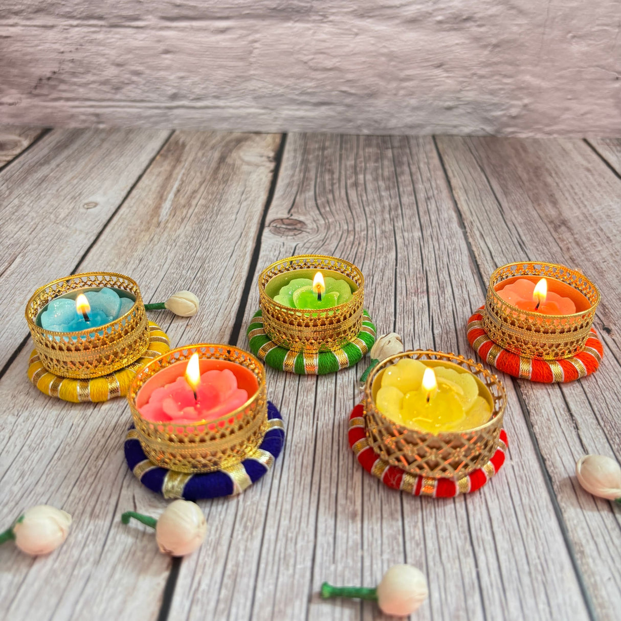 Colorful decorative tealight candles in ornate golden holders for festive home decor