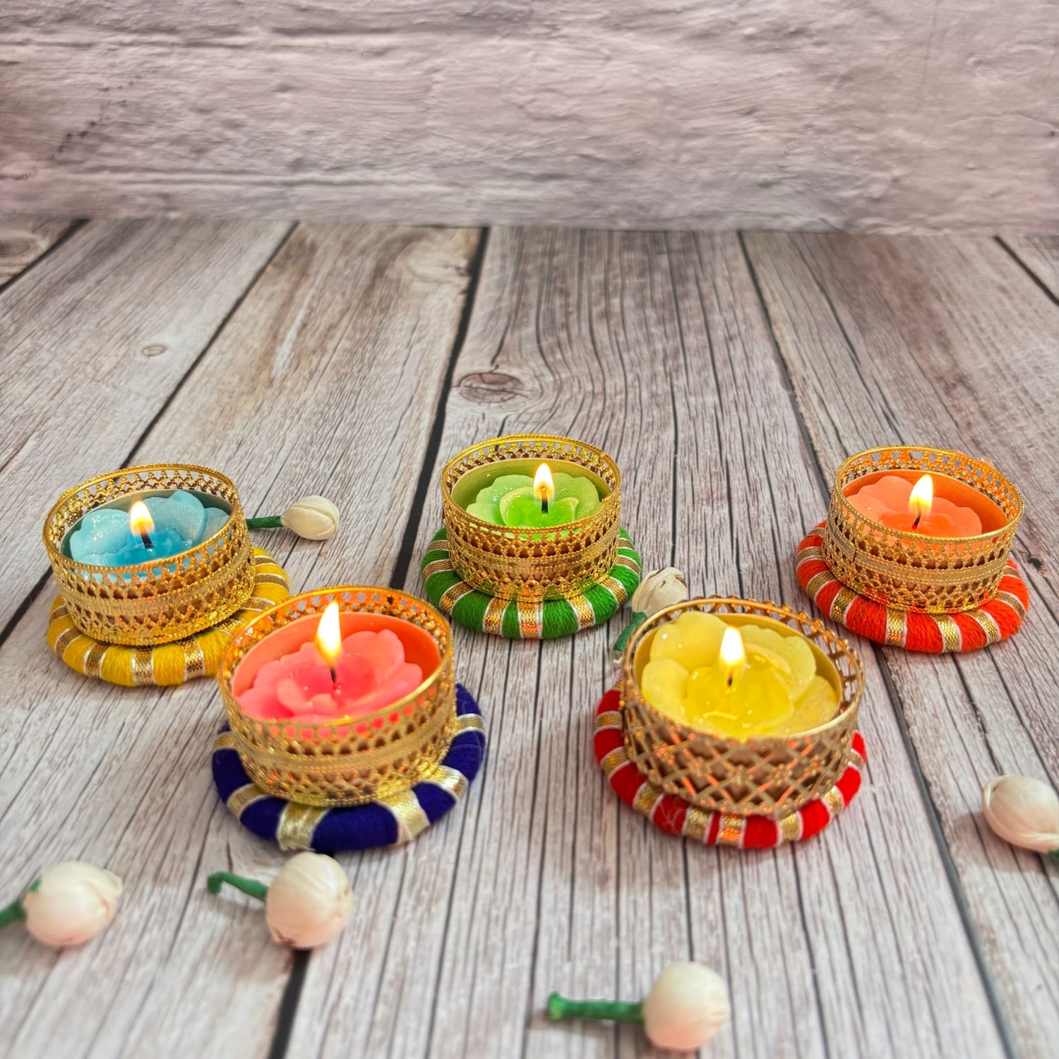 Colorful decorative tealight candles in ornate golden holders for festive home decor
