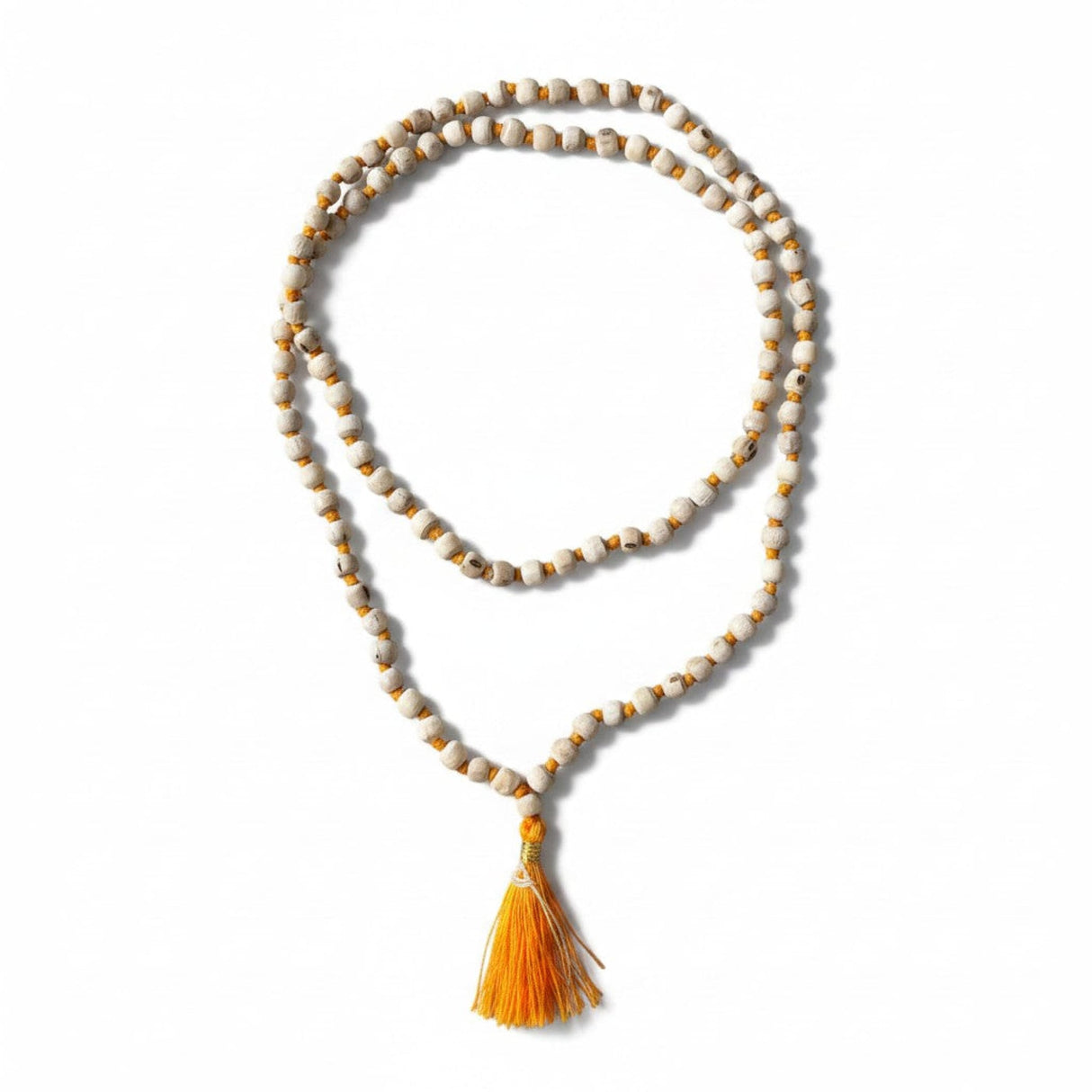 A delicate white and gold beaded tulsi holy basil japa mala necklace with a vibrant orange tassel for meditation and yoga