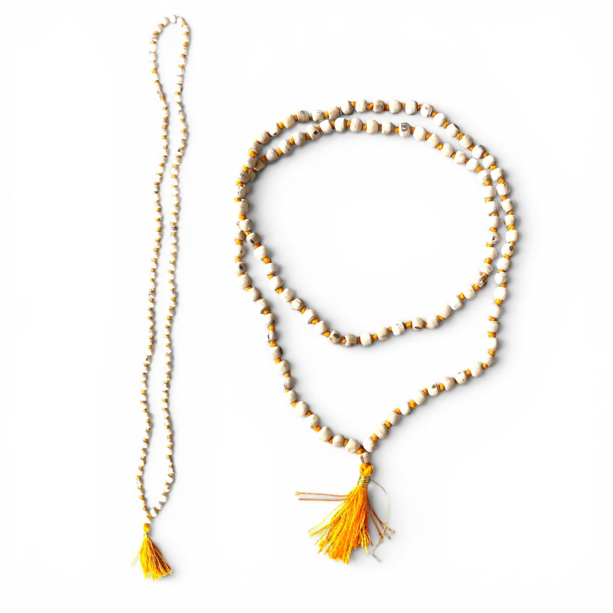 A long 5 mm tulsi mala beads necklace with alternating white and gold beads and a vibrant yellow tassel for meditation