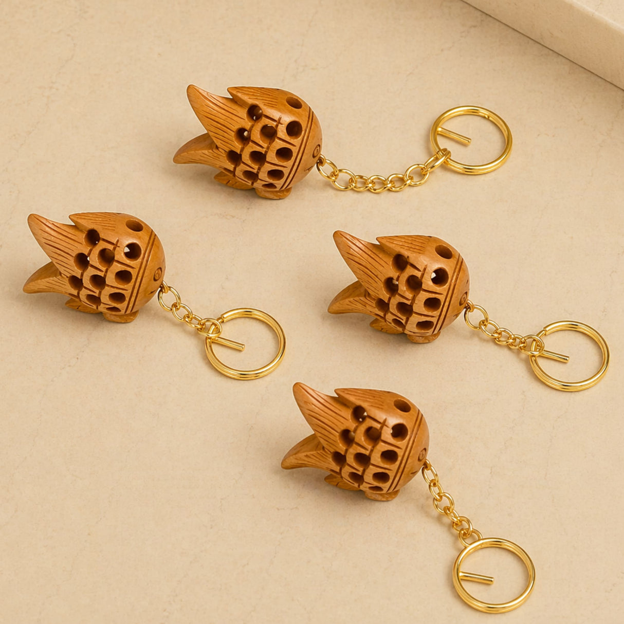 Four wooden fish-shaped keychains with gold-toned metal chains and rings for good luck and key holding gifts