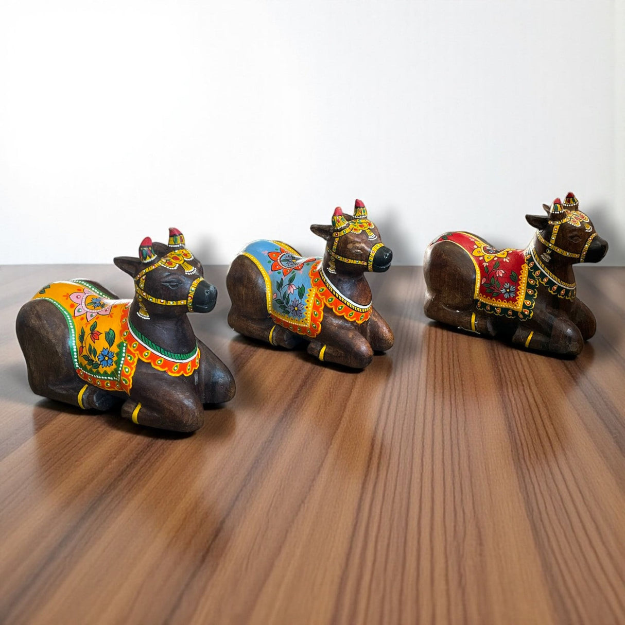 Handmade painted wooden Nandi cow idol with ornate saddle, 7.5 inch statue