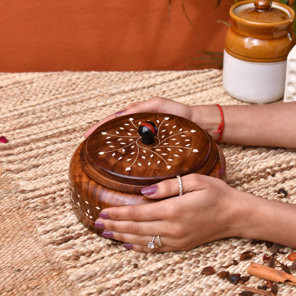 Handcrafted round wooden indian spice box organizer with intricate white inlay and dark brown lid for kitchen storage