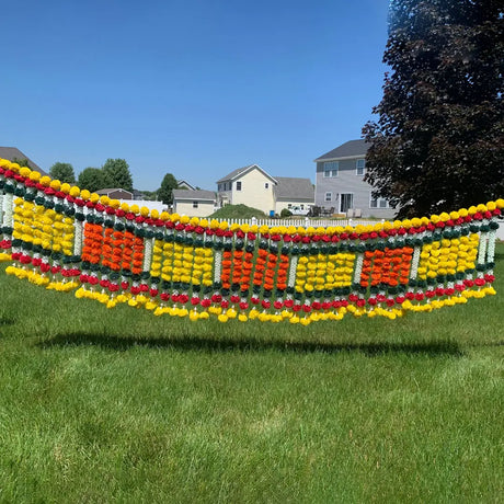 Colorful balloon arch with geometric pattern between trees complements flower torans in LoveNspire’s exquisite collection