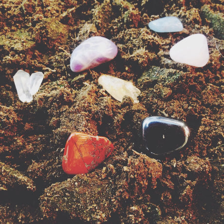 Different types of healing stones that are laid on the ground.