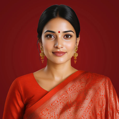 Elegant Indian woman in a red saree with gold earrings representing marital status and ajna chakra