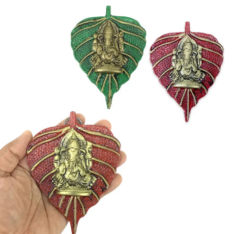 Gold Ganesha figurehead on a green leaf, symbolizing Indian return gifts for the diaspora.