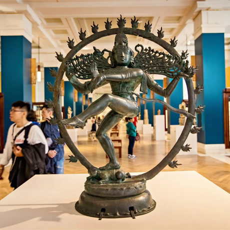 Ornate Indian statue with elaborate headdress, smiling face, embodying spiritual tranquility