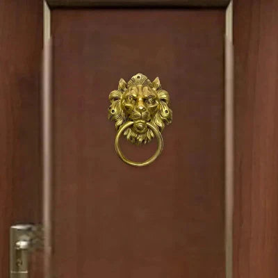 Ornate golden lion’s head brass door knocker with intricate designs and functional ring