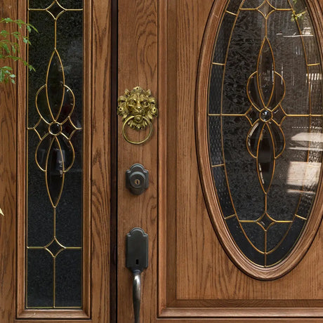 Wooden front door with decorative glass panels and a brass lion door knocker