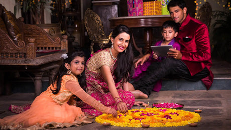 Family celebrating Diwali with floral rangoli and diyas, highlighting spiritual significance