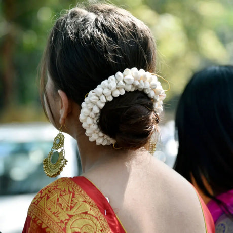 White floral hair accessory with indian gajra adorning a bun hairstyle in India’s rich cultural tapestry