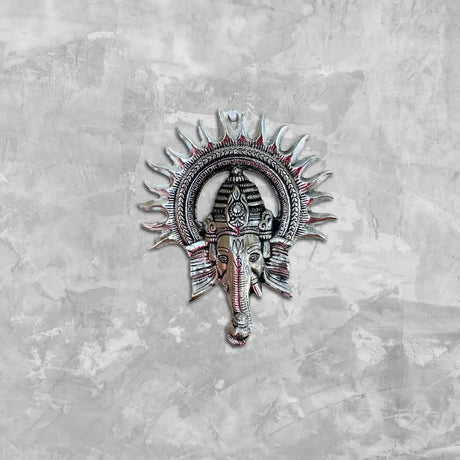 Ornate metallic Hindu statue artistry of Ganesha with sun-like halo for embracing divine presence