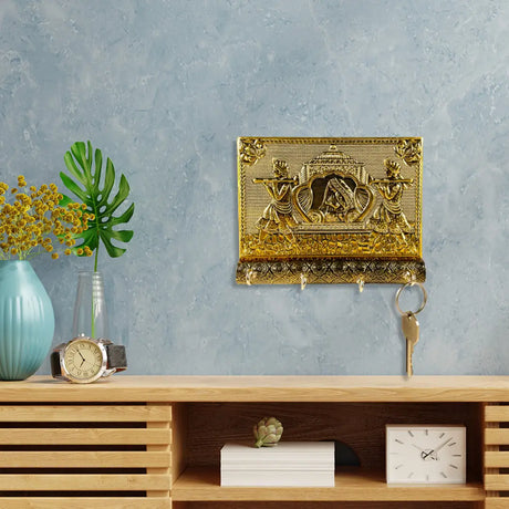 Ornate golden frame with decorative artwork showcasing an ethnic key holder on wall