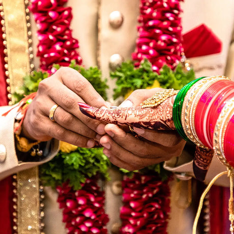 Hands exchanging a ring during a traditional Indian wedding ceremony showcasing exquisite Jaimala collections