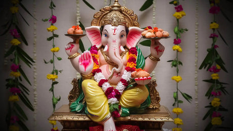 Brightly painted Ganpati Lord idol with garlands and sweets highlighting cultural significance