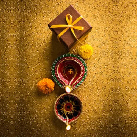 A colorful arrangement of traditional Indian handicrafts including earrings and bangles, surrounded by diya lamps, marigold flowers, and vibrant rangoli patterns, celebrating Diwali.