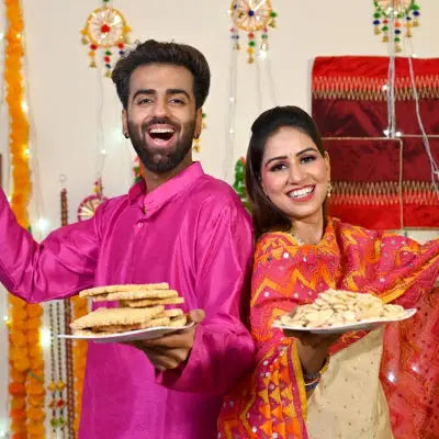 A man wearing a vibrant pink traditional kurta with embroidery for a lohri celebration featuring marigold garlands.