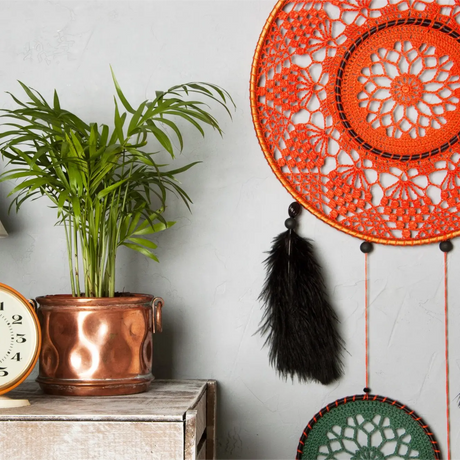 Cozy sectional sofa with vibrant orange and red pillows showcasing Indian home decor style