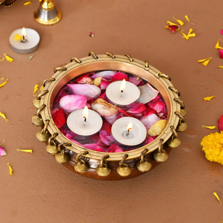 Brass urli with floating candles and rose petals for traditional Indian festive entertaining