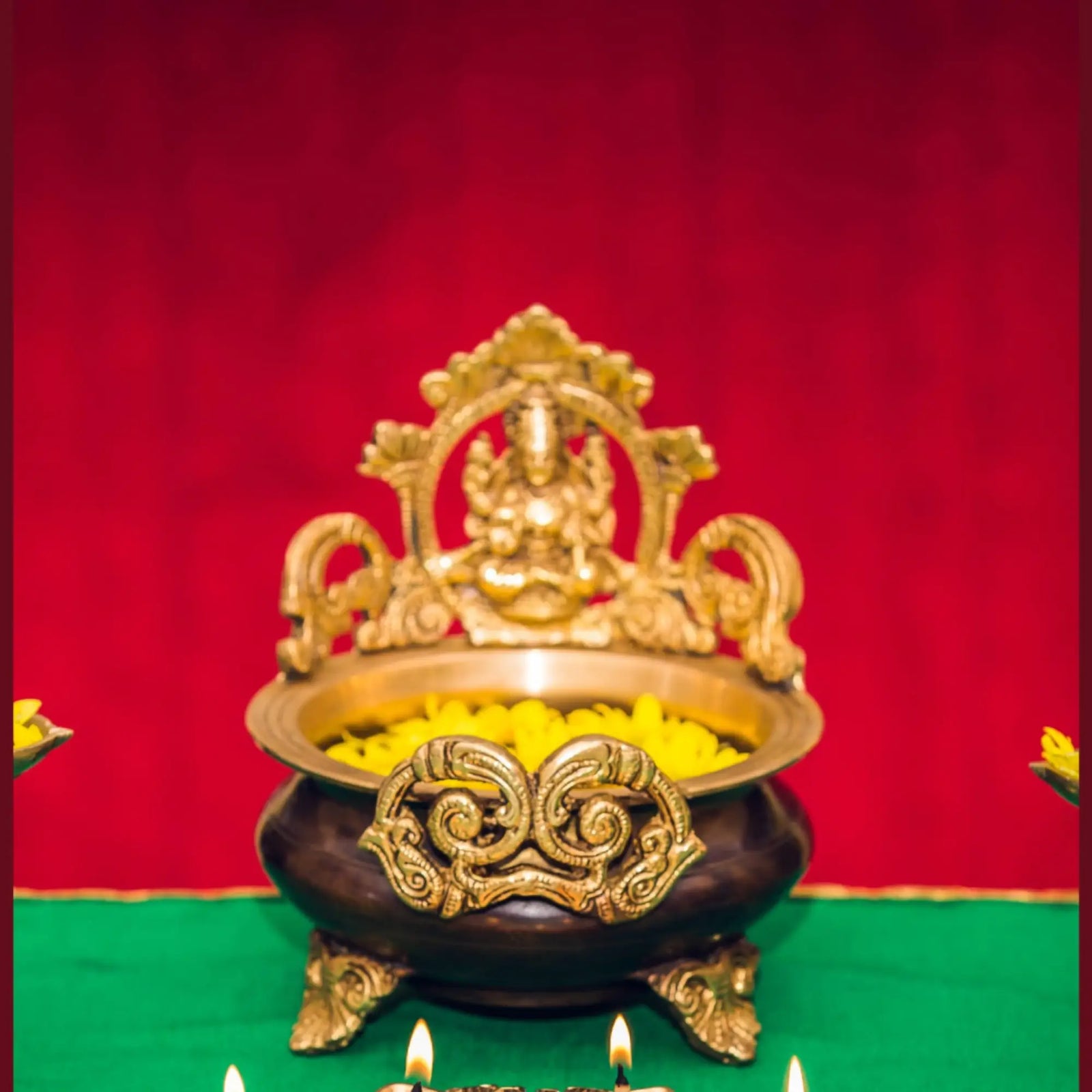 Ornate brass pot with deity figure and yellow flowers, ideal puja room decoration items