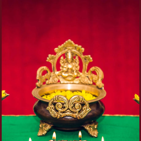 Ornate brass pot with deity figure and yellow flowers, ideal puja room decoration items
