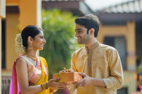 Man and woman exchanging a gift box for Raksha Bandhan with raksha bandhan gifts