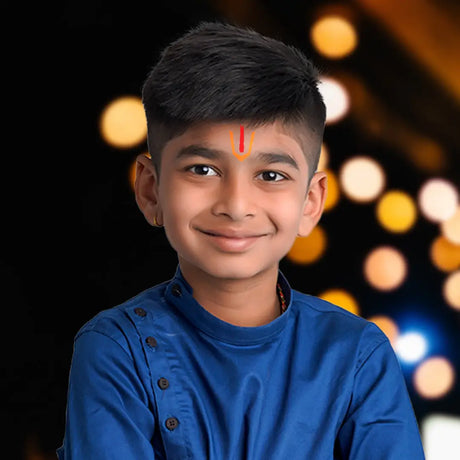 Young boy smiling in blue shirt during Dhoti Ceremony celebrating cultural roots and tradition
