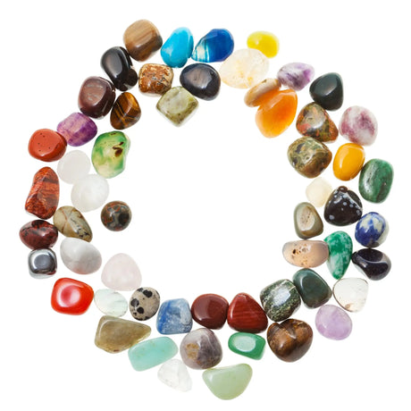 Different types of healing stones scattered on the white background.