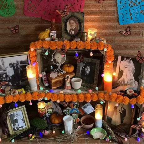 Colorful Day of the Dead altar with candles, photos, and offerings honoring los muertos