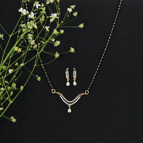 Gold chain mangalsutra with black beads, diamond pendant, and matching drop earrings