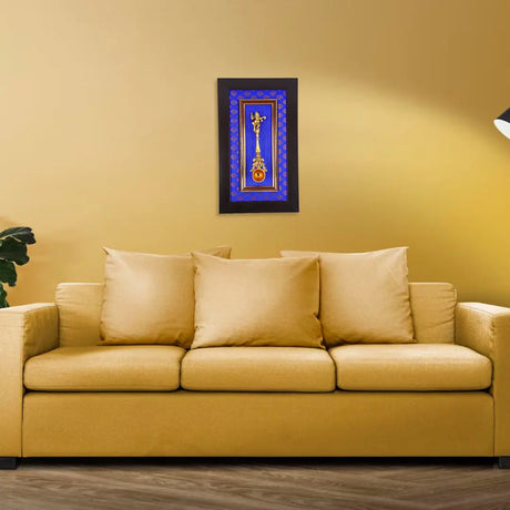 Beige couch with throw pillows beneath framed artwork, enhancing Hindu statues and Ganesha wall decor
