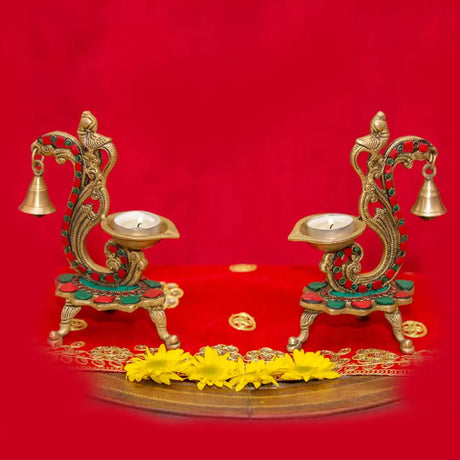 Ornate brass candle holders with bells and floral designs for traditional Indian home decor