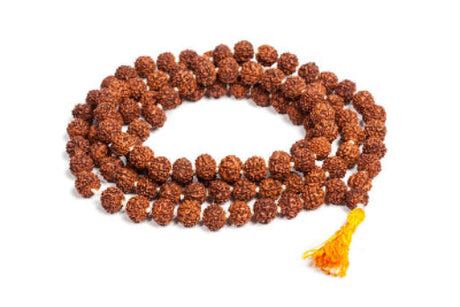 Close-up of a traditional Rudraksha mala with rich brown beads glowing softly against a serene background with subtle spiritual symbols