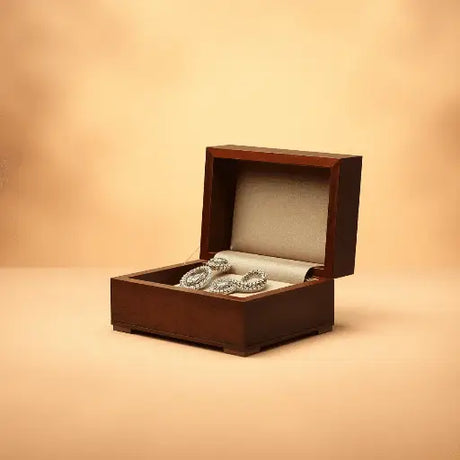 Open wooden jewelry box displaying sparkling elegant jewelry against a warm, soft background evoking timeless elegance and artistry.