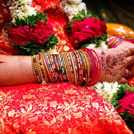 Colorful bangles on henna-decorated wrist exemplify vibrant celebration embraced in South Indian culture
