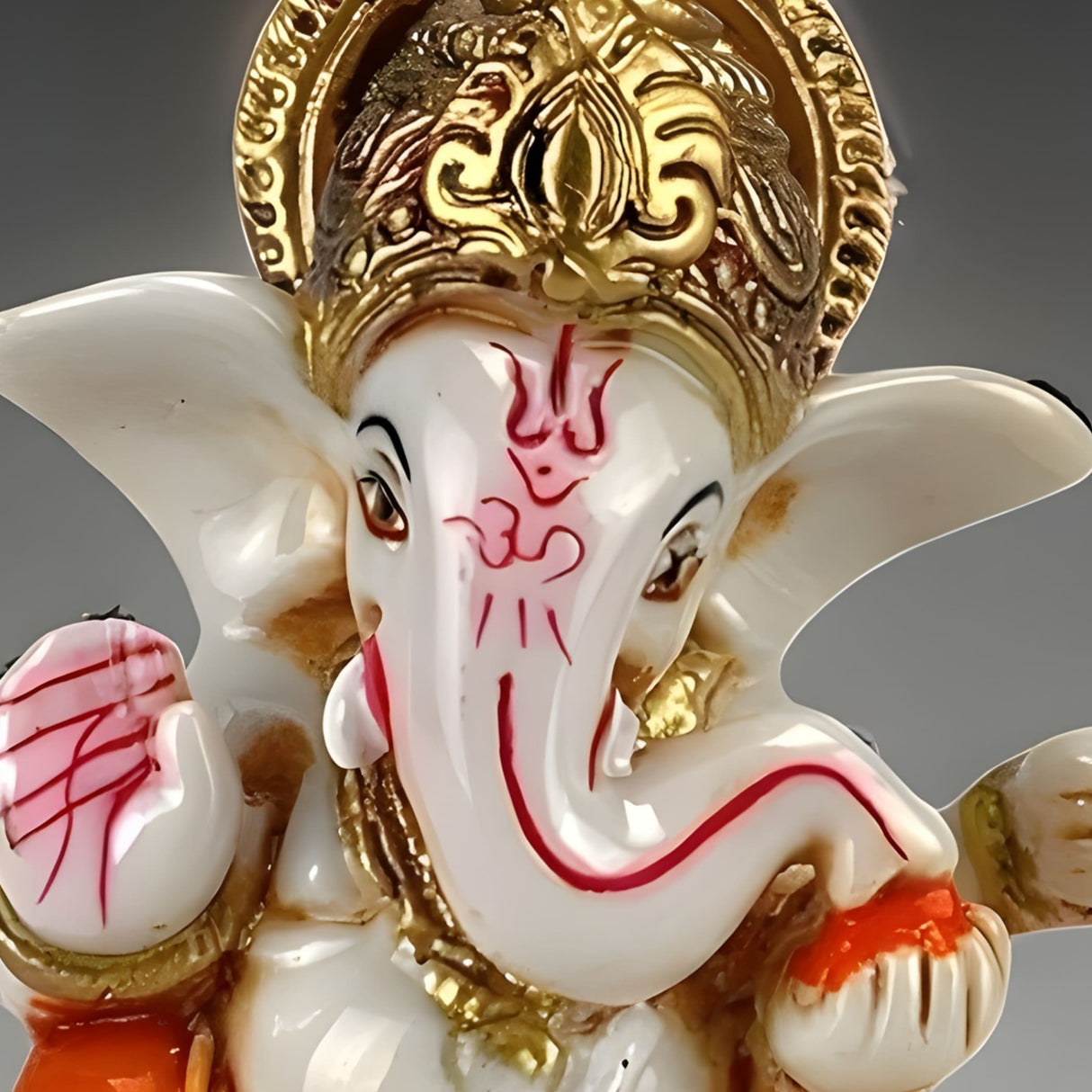 White and gold Ganesha statue with red face markings for car dashboard